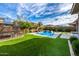 An amazing backyard featuring a refreshing pool, a trampoline, palm trees, and low maintenance artificial turf at 3320 E Tina Dr, Phoenix, AZ 85050