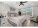 Relaxing bedroom with a brick accent wall, plush bedding, a ceiling fan and neutral color palette at 3320 E Tina Dr, Phoenix, AZ 85050