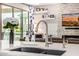 Close up of a kitchen featuring sleek countertops, stylish faucets, and a view into a cozy living space at 3320 E Tina Dr, Phoenix, AZ 85050