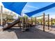 Community playground with a slide, climbing bars and stairs under a blue shade covering at 3320 E Tina Dr, Phoenix, AZ 85050