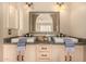 Well-lit bathroom features a double sink with granite countertop and decorative mirror at 3801 E Kent Dr, Phoenix, AZ 85044