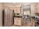 Kitchen featuring stainless steel refrigerator, granite countertops, and light wood cabinets adjacent to dining area at 3801 E Kent Dr, Phoenix, AZ 85044