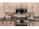 Close-up of a kitchen with stainless steel appliances, granite countertops, and light wood cabinets at 3801 E Kent Dr, Phoenix, AZ 85044