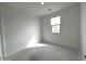 Bright bedroom with large window and neutral walls with concrete floors at 4328 E Bradford Ave, San Tan Valley, AZ 85140