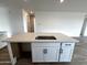 Kitchen island features stainless sink, white cabinets, quartz counters and modern fixtures at 4328 E Bradford Ave, San Tan Valley, AZ 85140