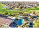 A community pool with a spa and ramada surrounded by lush golf course and community landscaping at 4439 E Ficus Way, Gilbert, AZ 85298