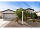 Home's inviting exterior with a two-car garage, complemented by desert landscaping and a well-maintained lawn at 4439 E Ficus Way, Gilbert, AZ 85298