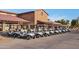 A row of golf carts lined up neatly in front of a clubhouse with a rust-colored roof at 4439 E Ficus Way, Gilbert, AZ 85298