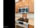 Stainless steel oven, cooktop and microwave with tile backsplash and granite countertops at 4439 E Ficus Way, Gilbert, AZ 85298