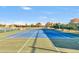 A full view of an outdoor tennis court with newly painted lines, green and blue surfaces, and mature landscaping at 4439 E Ficus Way, Gilbert, AZ 85298