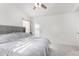 Bright bedroom features a ceiling fan, white walls and a large bed with grey upholstered headboard at 4507 E Towne Ln, Gilbert, AZ 85234