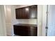 Laundry room with dark brown cabinets and countertop space at 5840 S Pico St, Gilbert, AZ 85298