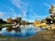 Scenic community pond features abundant wildlife, a rock waterfall, and mature landscaping under bright skies at 5840 S Pico St, Gilbert, AZ 85298