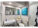 Modern bathroom with a white pedestal sink, glass shower, and stylish art at 7439 E Beryl Ave, Scottsdale, AZ 85258