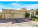 Tan two-story home with a tile roof, landscaping, and a two-car garage at 7439 E Beryl Ave, Scottsdale, AZ 85258