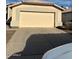 Tan house with a two-car garage and a long driveway at 8553 N 112Th Ave, Peoria, AZ 85345