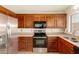 Well-lit kitchen features stainless steel appliances and wood cabinetry at 8553 N 112Th Ave, Peoria, AZ 85345