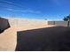 Empty lot with block wall and some sparse desert landscaping at 9526 W Luxton Ln, Tolleson, AZ 85353