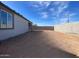 Large backyard with block wall and dirt. Some sparse vegetation at 9526 W Luxton Ln, Tolleson, AZ 85353