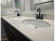 Close up on bathroom vanity with double sink with quartz countertops and modern fixtures at 9526 W Luxton Ln, Tolleson, AZ 85353