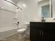 Modern bathroom with dark vanity, black fixtures, and a bathtub with white tile surround at 9526 W Luxton Ln, Tolleson, AZ 85353