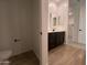 Bathroom featuring double sinks, black hardware, and access to toilet and bedroom at 9526 W Luxton Ln, Tolleson, AZ 85353