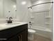 A bathroom featuring a shower-tub combo, dark vanity and a large mirror at 9526 W Luxton Ln, Tolleson, AZ 85353