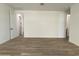 Large bedroom with wood-look tile flooring, white walls, and open doorway at 9526 W Luxton Ln, Tolleson, AZ 85353