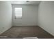 Bright, carpeted bedroom with a window and white walls, creating a clean and simple space at 9526 W Luxton Ln, Tolleson, AZ 85353