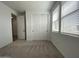 A bright, carpeted bedroom featuring a double-door closet and a window with blinds at 9526 W Luxton Ln, Tolleson, AZ 85353