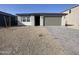 Charming single-story home with a gray exterior, gravel front yard, and paved driveway at 9526 W Luxton Ln, Tolleson, AZ 85353