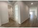 Bright hallway with wood-look floors and white walls leading to bedrooms and bathrooms at 9526 W Luxton Ln, Tolleson, AZ 85353