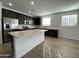 Spacious kitchen with dark cabinetry, stainless steel appliances, island, and bright countertops at 9526 W Luxton Ln, Tolleson, AZ 85353