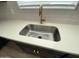 Close up of the kitchen sink featuring a stainless steel basin, gold faucet, and bright countertops at 9526 W Luxton Ln, Tolleson, AZ 85353