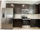 Well-equipped kitchen with stainless steel appliances and dark wood cabinetry at 9526 W Luxton Ln, Tolleson, AZ 85353