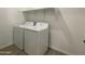 Bright laundry room with white washer and dryer, and convenient overhead shelving at 9526 W Luxton Ln, Tolleson, AZ 85353