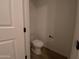 Cozy powder room featuring a toilet, neutral wall color, and wood-look flooring at 9526 W Luxton Ln, Tolleson, AZ 85353