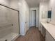 Modern bathroom with a glass-enclosed shower, vanity with sink, and wood-look tile flooring at 9530 W Luxton Ln, Tolleson, AZ 85353