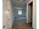 Hallway view of a bedroom with neutral carpet and a bright window at 9530 W Luxton Ln, Tolleson, AZ 85353