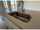 Close-up of kitchen island sink featuring modern faucet and countertop, with a stylish and functional design at 9530 W Luxton Ln, Tolleson, AZ 85353