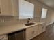 Close-up of the kitchen sink with stainless steel appliances and white cabinets at 9534 W Luxton Ln, Tolleson, AZ 85353