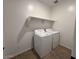 Functional laundry room featuring modern washer and dryer units with overhead shelving at 9534 W Luxton Ln, Tolleson, AZ 85353