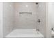 Clean bathtub with marble-look tile surround at 9832 W Oraibi Dr, Peoria, AZ 85382