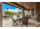 Covered back patio with outdoor furniture that overlooks a refreshing pool and green landscaping at 10971 W Tonopah Dr, Peoria, AZ 85373