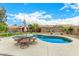 Backyard featuring a kidney-shaped pool, lush landscaping, and patio seating for outdoor entertaining and relaxation at 10971 W Tonopah Dr, Peoria, AZ 85373