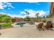 This backyard features a kidney-shaped pool, mature landscaping, and seating for relaxing and entertaining at 10971 W Tonopah Dr, Peoria, AZ 85373