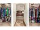 Through two closet spaces is a bedroom with a ceiling fan and a wooden bed frame on tan carpet flooring at 10971 W Tonopah Dr, Peoria, AZ 85373