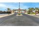 Community entrance with palm trees, landscaping, and 