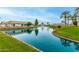 Scenic pond with a fountain, lush green banks, palm trees, and a building in the background under a clear blue sky at 10971 W Tonopah Dr, Peoria, AZ 85373