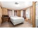 Simple bedroom with wood paneling, a double bed, and a writing desk at 11411 N 91 Ave # 56, Peoria, AZ 85345